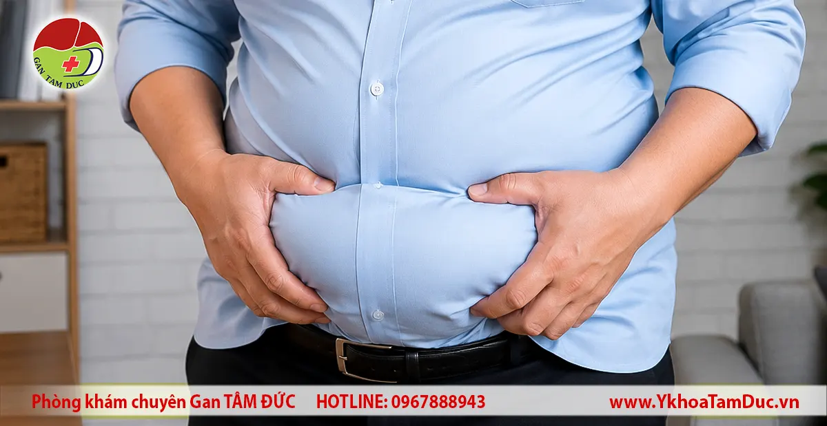 Gan nhiễm mỡ có làm bụng to không? 1 Người trưởng thành với vòng bụng lớn đang dùng hai tay ôm bụng, minh họa tình trạng bụng to thường gặp; hình ảnh không thể xác định nguyên nhân như gan nhiễm mỡ hay các bệnh lý khác.