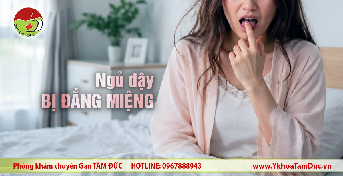 Sáng sớm ngủ dậy bị đắng miệng: Tự đánh giá & Cách xử lý 1 Phụ nữ ngồi trên giường chạm tay vào miệng thể hiện cảm giác đắng miệng khi vừa ngủ dậy, kèm thông tin Phòng khám Gan Tâm Đức.